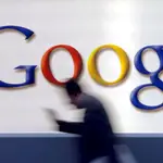 A man passes by a Google logo in Frankfurt, Germany,