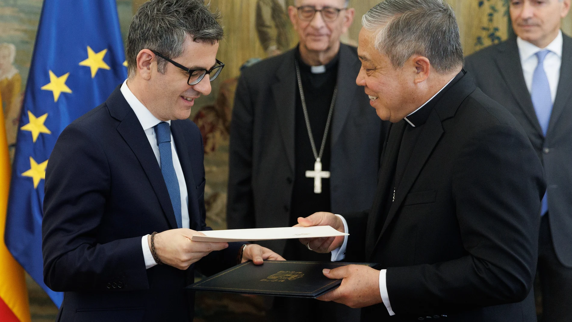 El ministro de la Presidencia, Relaciones con las Cortes y Memoria Democrática, Félix Bolaños (i) y el Nuncio Apostólico, Monseñor Bernardito Auza (c), durante un cambio de notas, en el Palacio de Santa Cruz, a 29 de marzo de 2023, en Madrid (España). Durante este encuentro, han realizado un intercambio de notas por el que la Iglesia Católica renuncia a sus privilegios fiscales y se comportará como cualquier organización sin ánimo de lucro.