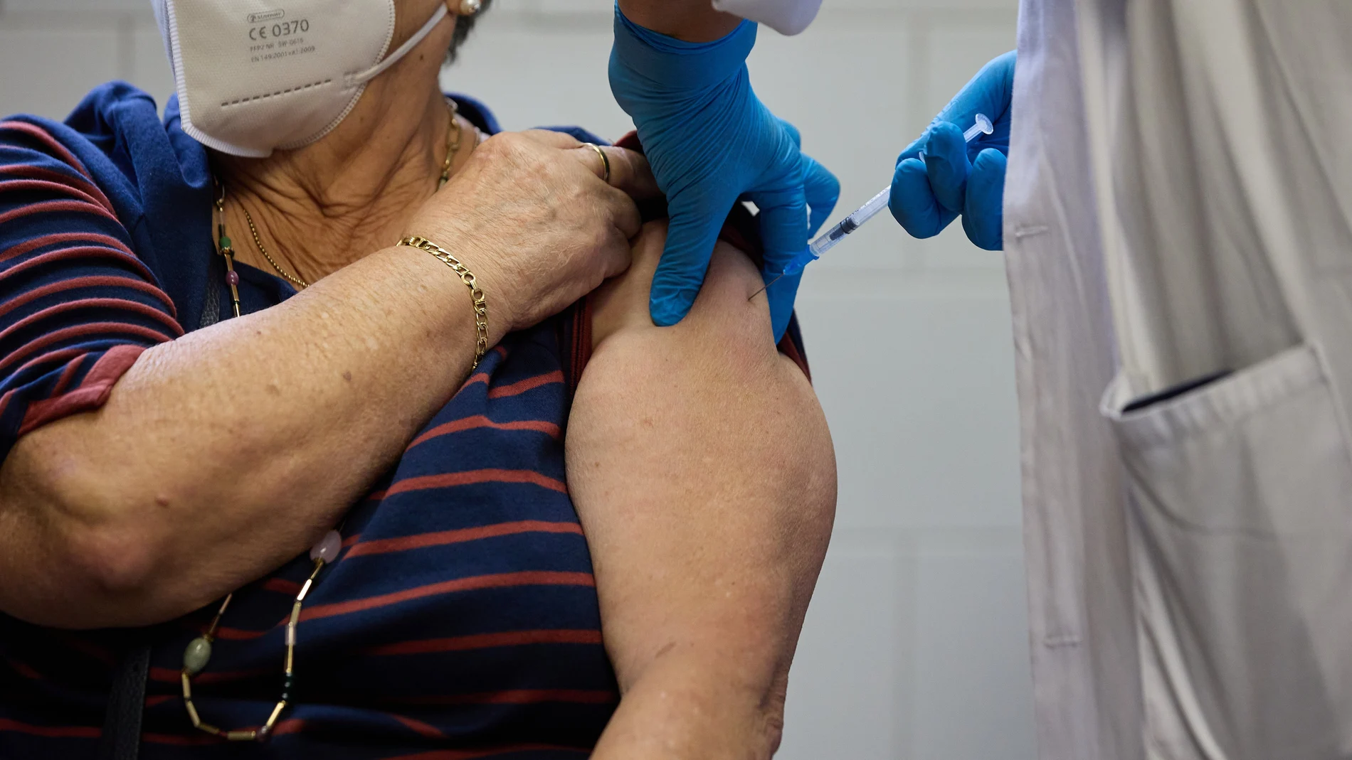 Un enfermero vacuna a una mujer en Madrid