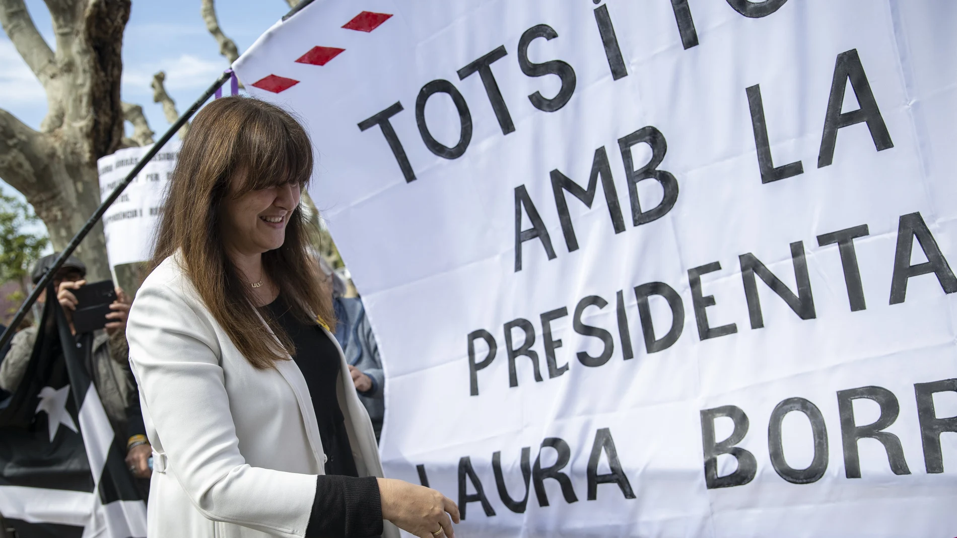 La presidenta de Junts y expresidenta del Parlament, Laura Borràs, delante de una pancarta que pide su absolución, tras ser condenada a cuatro años y medio de cárcel y trece de inhabilitación por el Tribunal Superior de Justicia Catalán, a 30 de marzo de 2023, en Barcelona, Cataluña.