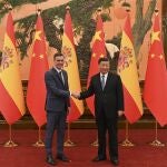 El presidente del Gobierno, Pedro Sánchez (i) saluda al presidente chino, Xi Jinping (d) durante su encuentro este viernes en el Gran Palacio del Pueblo en el marco de su visita oficial a China. 