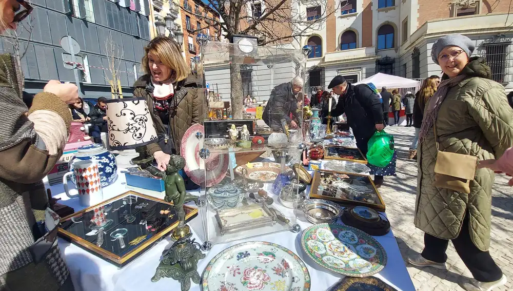 Uno de los puestos de 'Los Sábados del Rastro' expone platos, lámparas y objetos de decoración antiguos.