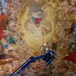 Raúl Berzosa ultima sobre un elevador los detalles de la "coronación de la Virgen María" en el techo del Oratorio de la Hermandad de las Penas de Málaga