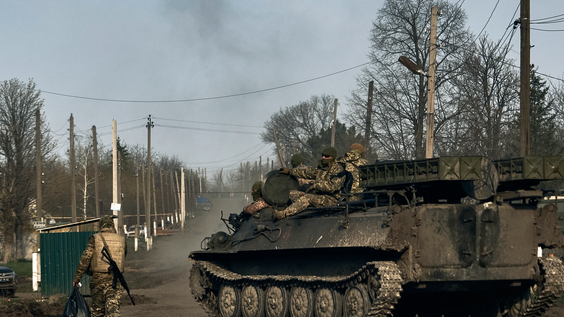 Ukrainian soldiers ride atop an APC in the heaviest battles with the Russian invaders in Bakhmut, Donetsk region, Ukraine, Sunday, April 9, 2023. (AP Photo/Libkos)