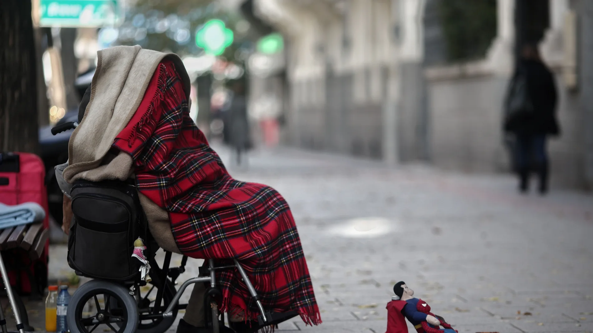 Una persona en silla de ruedas pidiendo en una céntrica calle
