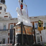 Varios obreros suben de nuevo la estatua de Carlos III a su pedestal este lunes en su nueva ubicación en la Puerta del Sol de Madrid.