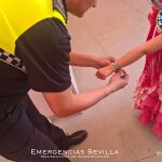 Un policía local pone una pulsera de seguridad a un niño