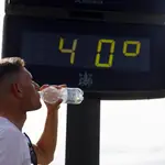 Un joven bebe agua junto a un termómetro en Córdoba a finales de abril