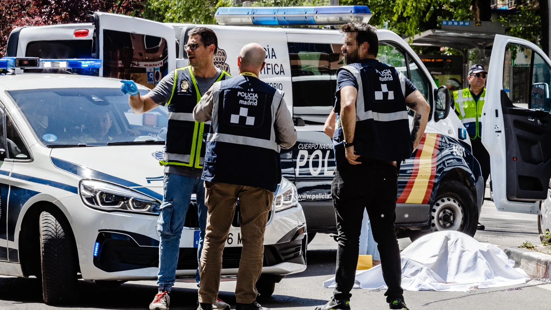 Agentes de las policías Nacional y Municipal junto a uno de los fallecidos hoy en el atropello mortal de Madrid