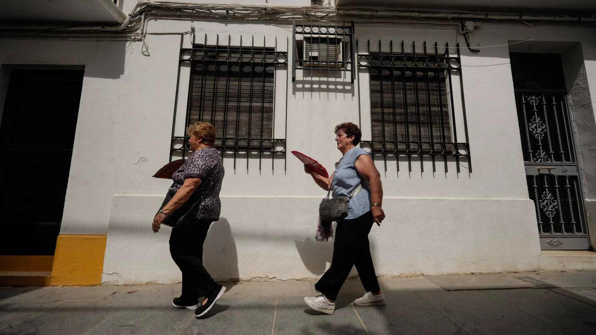 Un par de turistas se abanican para combatir el calor mientras pasean por las calles de Córdoba