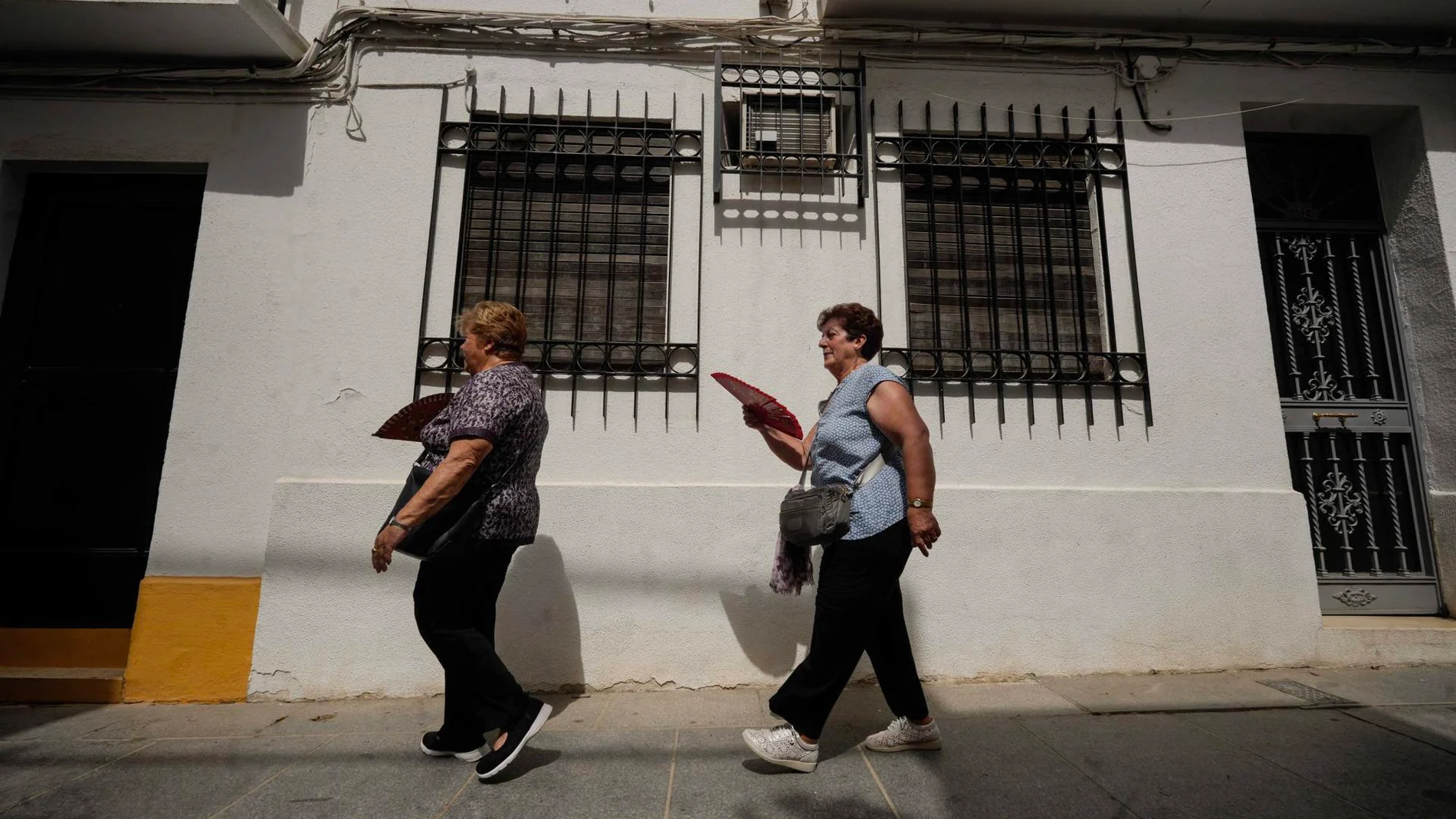 Un par de turistas se abanican para combatir el calor mientras pasean por las calles de Córdoba