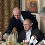 Businessman Yevgeny Prigozhin, left, serves food to Russian Prime Minister Vladimir Putin, center, during dinner at Prigozhin&#39;s restaurant outside Moscow, Russia, Friday, Nov. 11, 2011. 