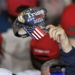  A supporter of former US president Donald Trump, waves a Trump 2024 campaign hat, before Trump addressed a crowd during a rally in Manchester, New Hampshire, USA