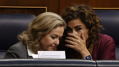 La vicepresidenta primera y ministra de Asuntos Económicos y Transformación Digital, Nadia Calviño (i), conversa con la ministra de Hacienda, María Jesús Montero (d), durante un pleno que se celebra, en el Congreso de los Diputados.