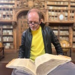 El novelista observa un libro en la histórica biblioteca de la Universidad de Salamanca