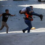 Palestinos evacuan a un hombre herido durante una redada israelí, en la ciudad de Naplusa