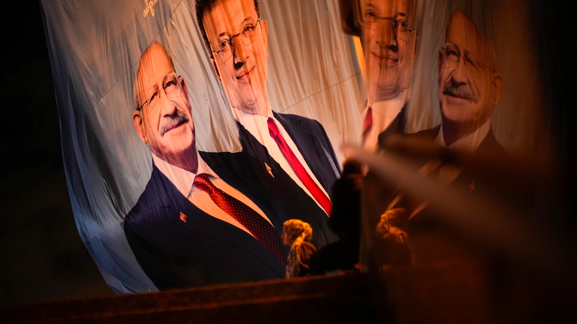A woman walks past a giant election campaign banner of Turkish CHP party leader and Nation Alliance's presidential candidate Kemal Kilicdaroglu, left, with Istanbul Mayor and co-party member Ekrem Imamoglu outside Taksim square metro station in Istanbul, Turkey, Wednesday, May 10, 2023. (AP Photo/Francisco Seco)