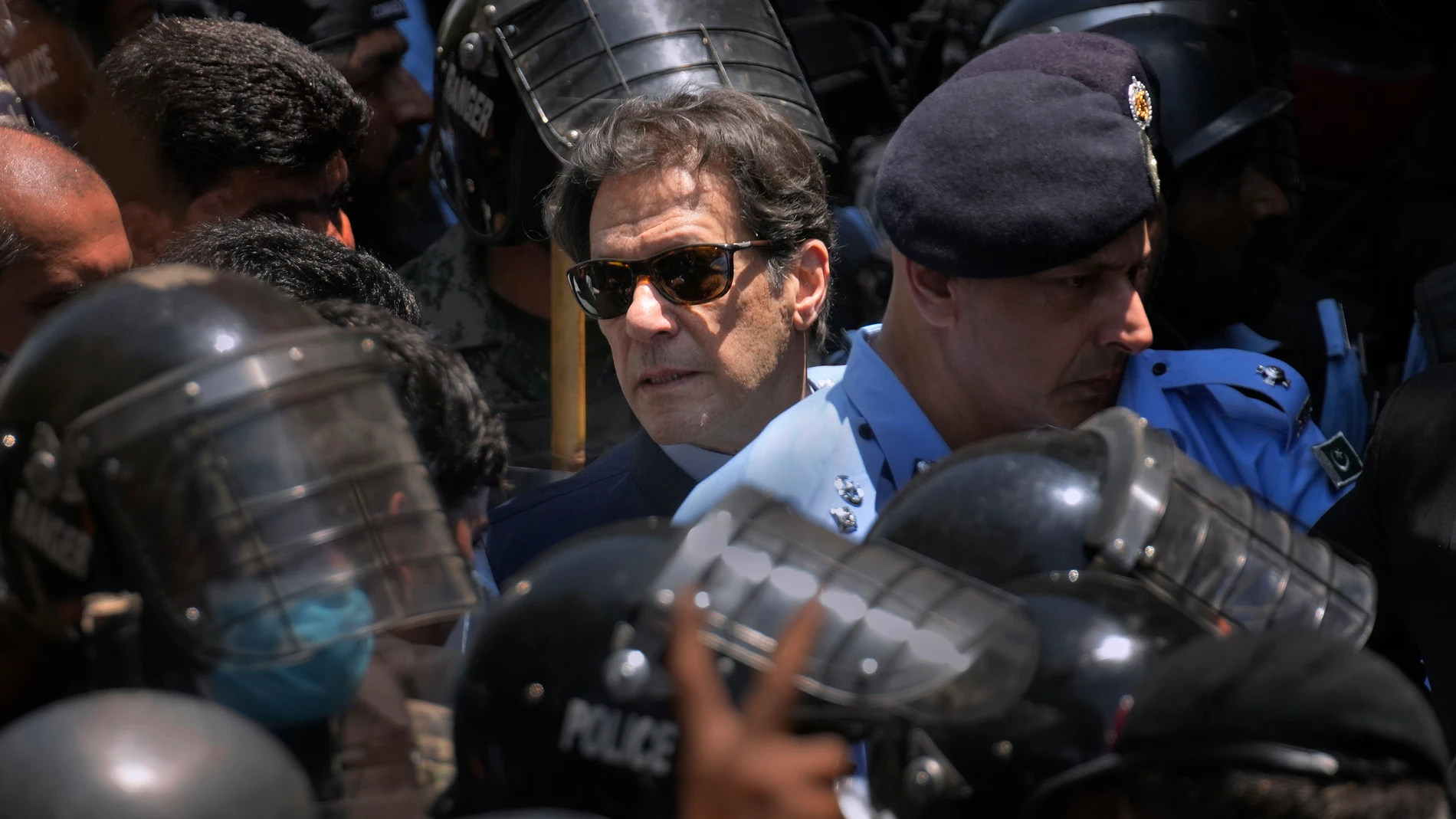 Pakistan's former Prime Minister Imran Khan, center, is escorted by police officers as he arrives to appear in a court, in Islamabad, Pakistan, Friday, May 12, 2023. A high court in Islamabad has granted Khan a two-week reprieve from arrest in a graft case and granted him bail on the charge. (AP Photo/Anjum Naveed)