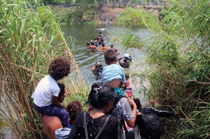 Migrantes cruzan el río Bravo para intentar ingresar a Estados Unidos hoy, en Matamoros (México). En la agonía del Título 42, los migrantes que se encuentran varados en la frontera de Matamoros, Tamaulipas, en el norte de México, han padecido crisis nerviosas y no han dejado de lanzarse al río Bravo durante este jueves, mientras los militares estadounidenses refuerzan la malla con púas y más agentes se suman a su tarea en la zona que las familias emplean para cruzar.