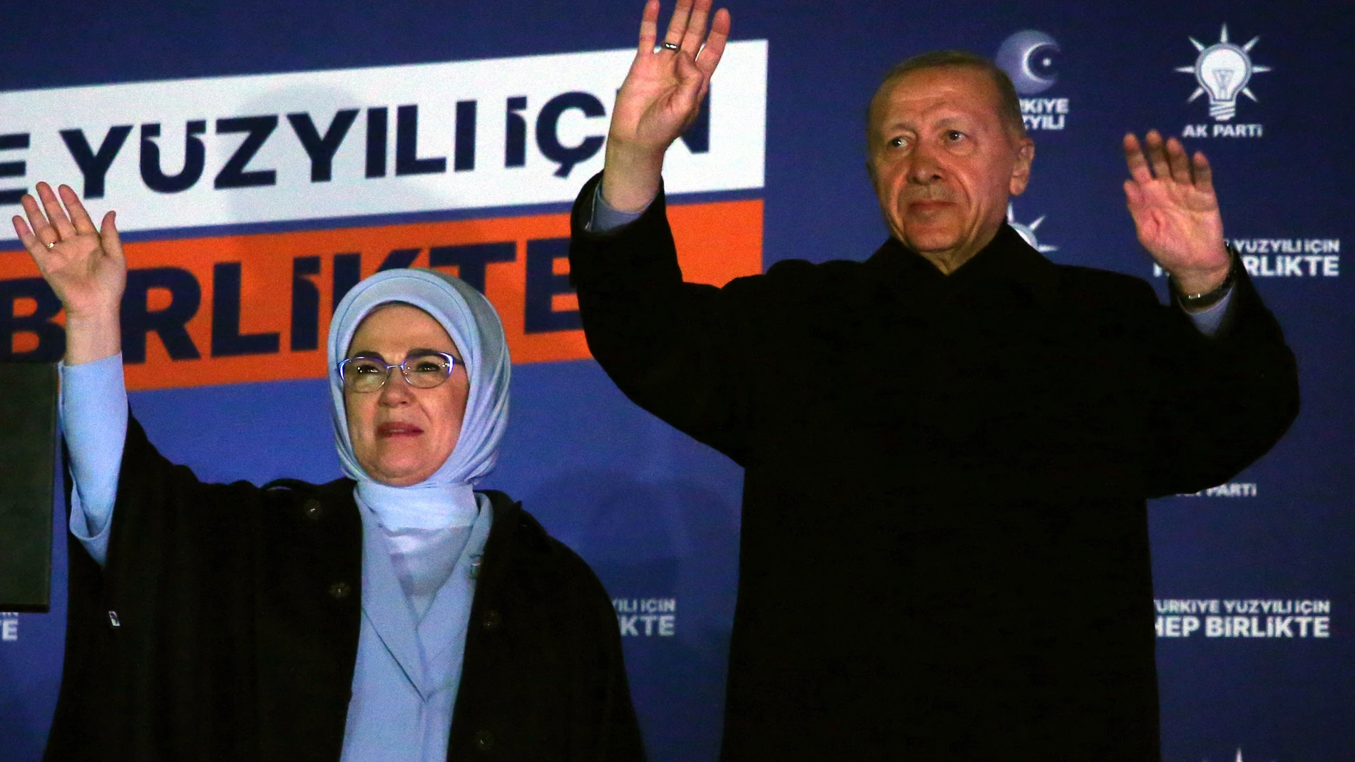 Turkish President Recep Tayyip Erdogan, right, and his wife Emine gesture to supporters at the party headquarters, in Ankara, Turkey, early Monday, May 15, 2023. Erdogan, who has ruled his country with an increasingly firm grip for 20 years, was locked in a tight election race Sunday, with a make-or-break runoff against his chief challenger possible as the final votes were counted. (AP Photo/Ali Unal)