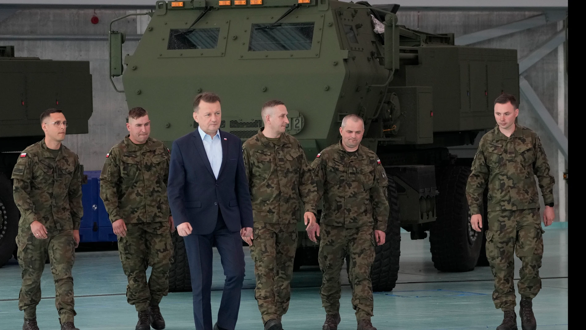 Poland's Defense Minister Mariusz Blaszczak, center, walks during ceremony after receiving its first shipment of U.S.-made HIMARS rocket launchers, at an air base in Warsaw, Poland, on Monday, 15 May 2023. Poland has received its first shipment of U.S.-made HIMARS rocket launchers, part of an upgrade of its defenses amid security concerns due to the war in neighboring Ukraine. (AP Photo/Czarek Sokolowski)