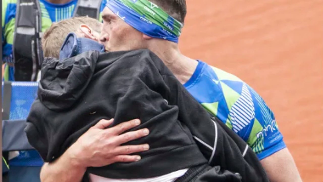 He crossed the finish line of the Leeds Marathon with his partner, who has ALS, in his arms