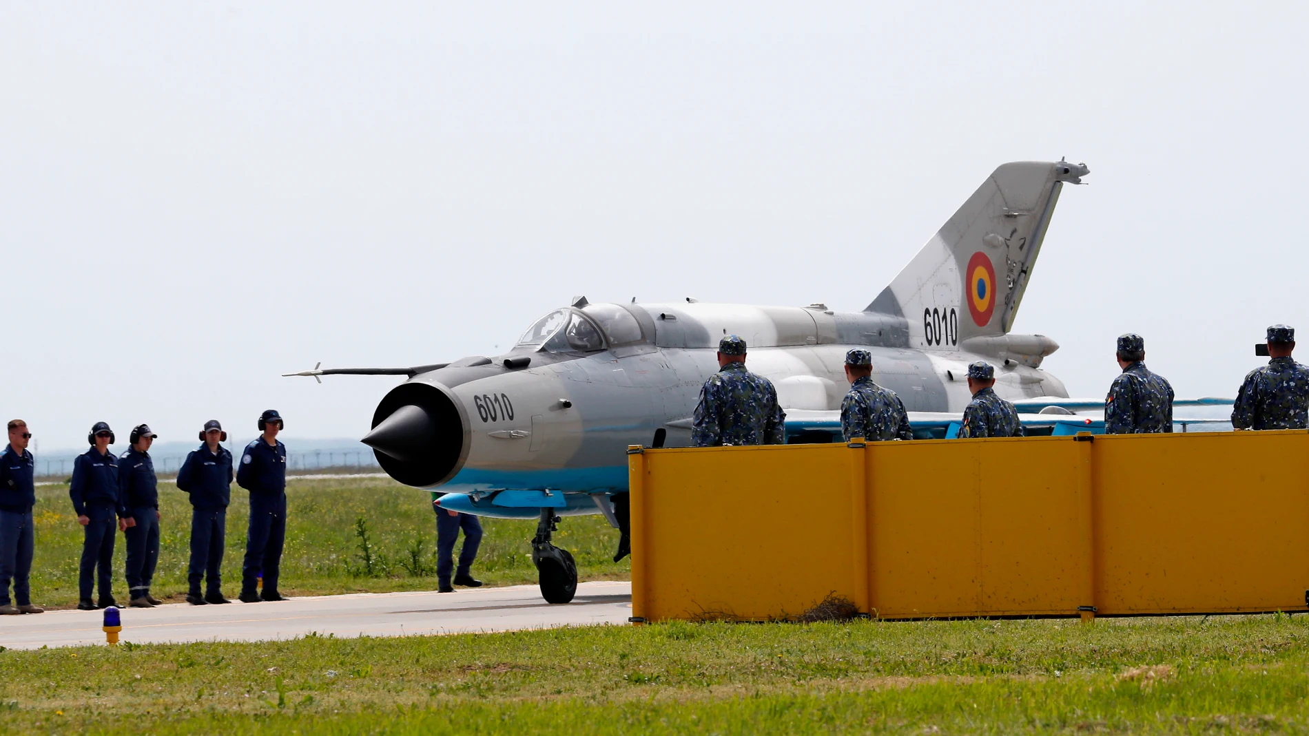 Borcea (Romania), 15/05/2023.- A Romanian Air Force MiG-21 LanceR is watched by a ground crew as it taxis to its last take-off during a decommissioning ceremony on the 86th Air Base, in Borcea, 156 kilometers south-east from Bucharest, Romania, 15 May 2023. The ceremony at the 'Lieutenant Aviator Gheorghe Mociornita' Air Base was completed with a last flight of the Mig21 LanceR warplanes of Soviet production after which they will be taken out of service based on a decision of the Romanian Supreme Council of Defense. Romania opted for F16 aircrafts with which the Romanian Air Force will continue to perform the permanent Air Police Combat Service within the mission of the Reinforced Air Police under NATO command. Romania has firmed up plans to acquire the Lockheed Martin F-35 Lightning II Joint Strike Fighter, the Romanian Ministry of Defence being expected to submit a formal letter of request to the US government before the end of 2024. The Mikoyan-Gurevich MiG-21 (NATO name: Fishbed) is a supersonic jet fighter and interceptor aircraft, designed in the former Soviet Union and entered service in 1959. Romanian Air Forces modernized its MIG-21 fleet by using the services of Israeli company ELBIT for its upgraded version MIG-21 LanceR. The jet was the most-produced supersonic jet aircraft in aviation history, the most-produced combat aircraft since the Korean War and the longest production run of any combat aircraft (apart from US jet fighters F15 and F16). From 1994 to 2023, the Air Force has lost approximately 20 MiG21s in accidents. Romania needs 48 aircraft to carry out its air police missions alone and to fulfill the combat requirements, according to Romania's commitments upon joining NATO. (Rumanía, Bucarest) EFE/EPA/ROBERT GHEMENT 