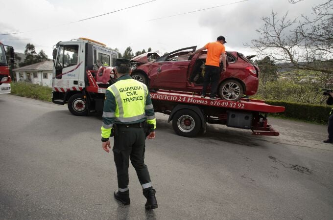 Un Guardia Civil vigila la retirada del coche siniestrado, en un accidente en el que fallecieron otros cuatro jóvenes -con edades comprendidas entre 17 y 19 años, en Xove, Lugo, Galicia.