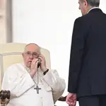 Ciudad del Vaticano.- 17/05/2023.- El Papa Francisco habla por teléfono durante su audiencia general del miércoles en la Plaza de San Pedro en el Vaticano.