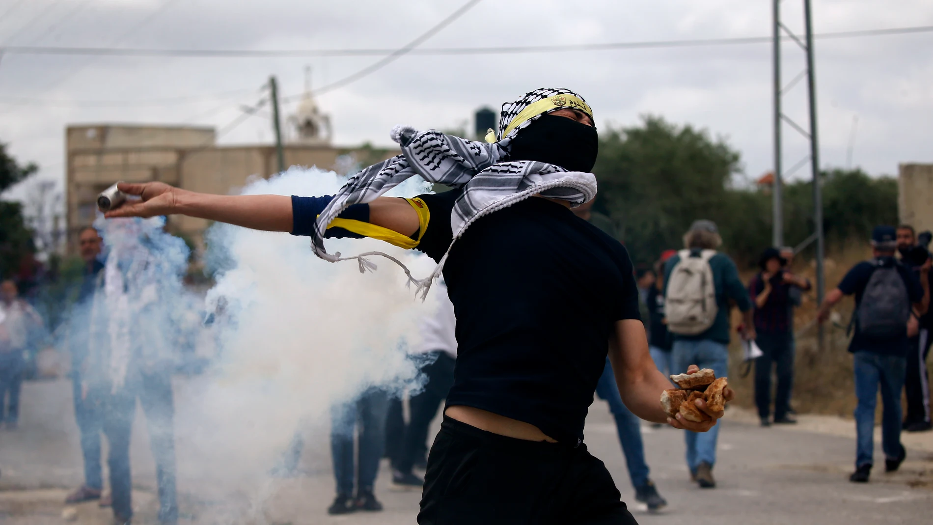 Nablus (-), 19/05/2023.- A Palestinian protester throws back a tear gas grenade during clashes with Israeli troops after a demonstration against Israel's settlements on the lands of Kafr Qaddum village, near the West Bank city of Nablus, 19 May 2023. (Protestas) EFE/EPA/ALAA BADARNEH 16727
