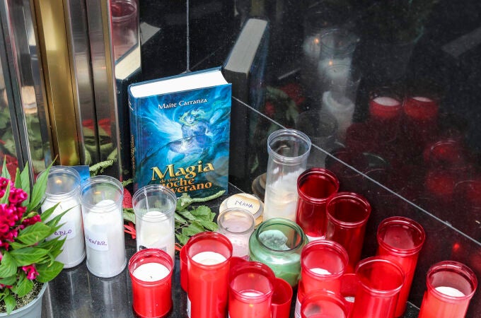 Velas, flores y un libro  en el portal de la calle Facetos de Oviedo en el que vivían las mellizas Alexandra y Anastasia