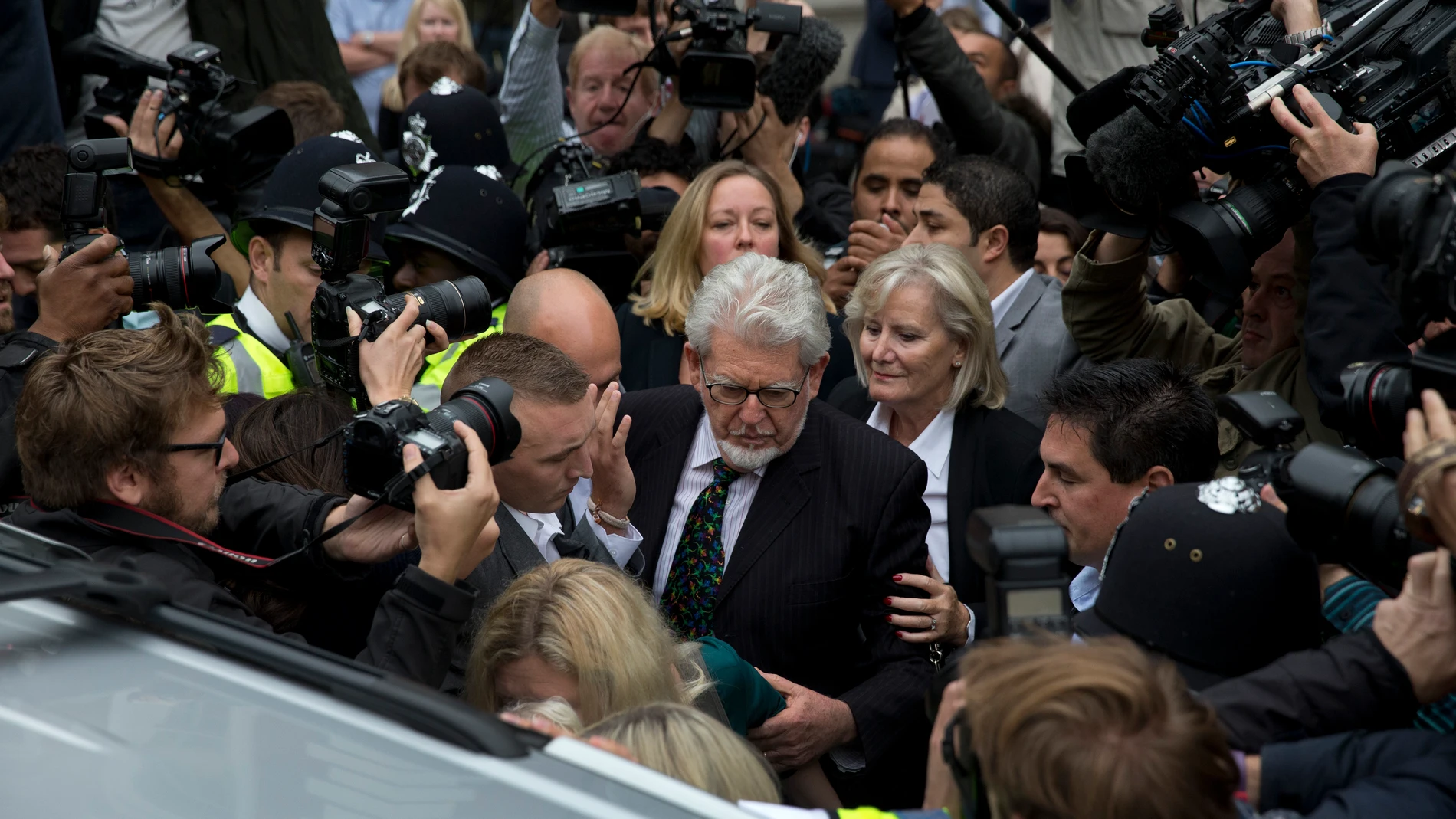 FILE - Veteran entertainer Rolf Harris, center, leaves Westminster Magistrate's Court in London, Monday, Sept. 23, 2013. Rolf Harris, the veteran entertainer whose decades-long career as a family favorite on British and Australian television was shattered when he was convicted of sexual assaults on young girls, has died. He was 93. (AP Photo/Matt Dunham, File)