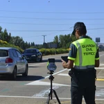  Un agente de la Guardia Civil maneja un radar en una carretera 