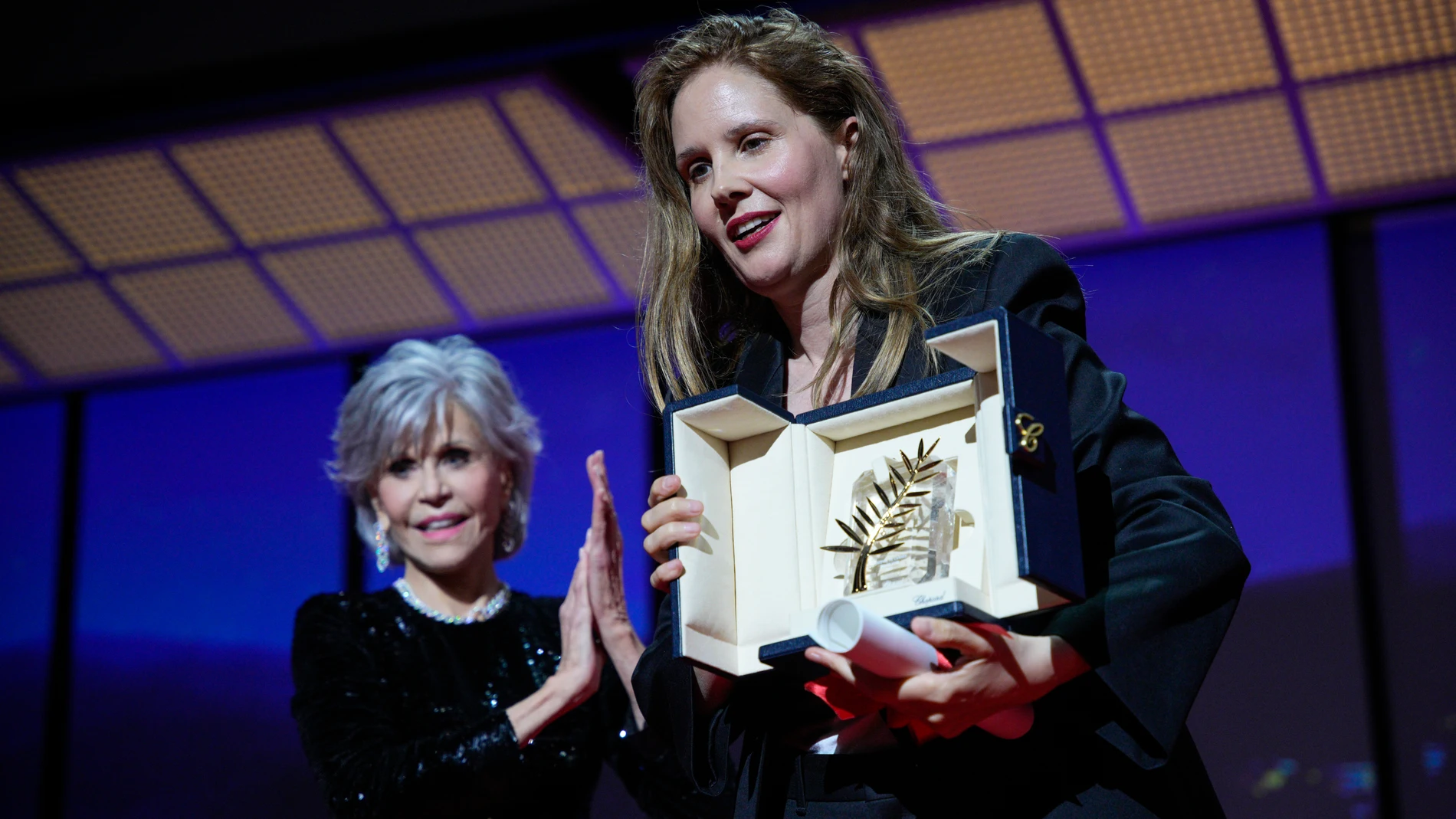 Justine Triet, right, accepts the Palme d'Or for 'Anatomy of a Fall,' which was presented by Jane Fonda, left, during the awards ceremony of the 76th international film festival, Cannes, southern France, Saturday, May 27, 2023 (AP Photo/Daniel Cole)