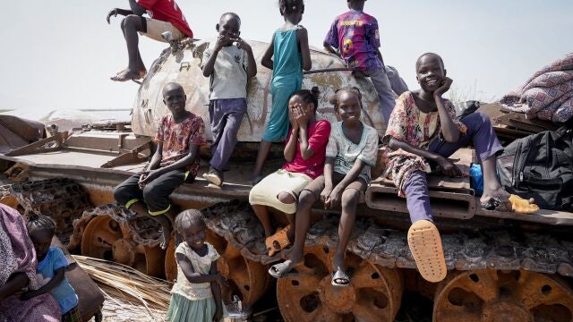 Children sit and play on the remains of a tank, at the river port in Renk, South Sudan Wednesday, May 17, 2023. Tens of thousands of South Sudanese are flocking home from neighboring Sudan, which erupted in violence last month.