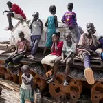 Children sit and play on the remains of a tank, at the river port in Renk, South Sudan Wednesday, May 17, 2023. Tens of thousands of South Sudanese are flocking home from neighboring Sudan, which erupted in violence last month.