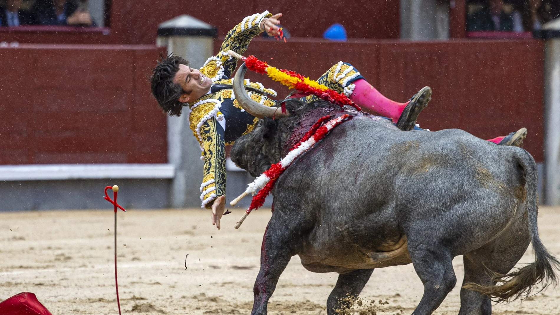 El diestro José Garrido sufre una cogida durante la faena a su primer toro, de la ganadería de Adolfo Martín, y que estoquea Fernando Robleño, en el decimosexto festejo de la Feria de San Isidro, que se celebra este domingo en la Monumental de las Ventas, Madrid.-