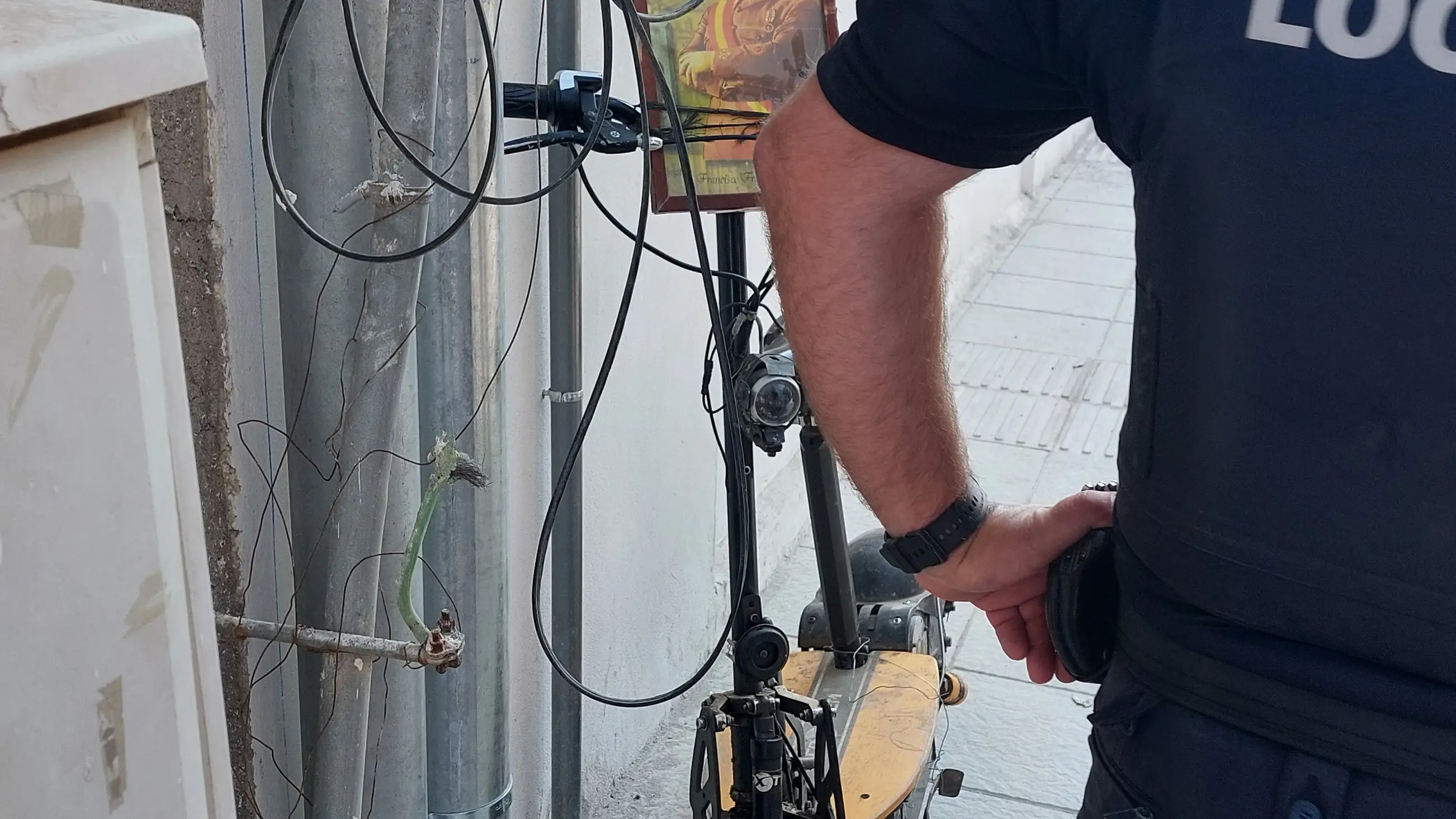 Un agente de la Policía Local de Adra junto al patinete con una fotode Franco empleado para el atropello