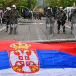 Una bandera serbia sobre la alambrada de las fuerzas de la OTAN 