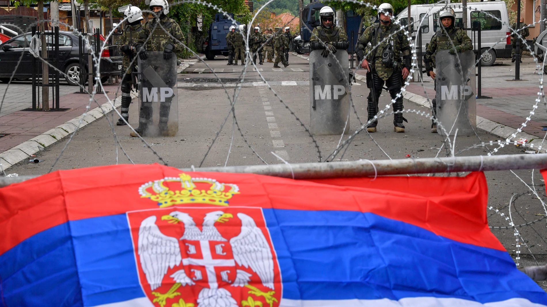Una bandera serbia sobre la alambrada de las fuerzas de la OTAN 