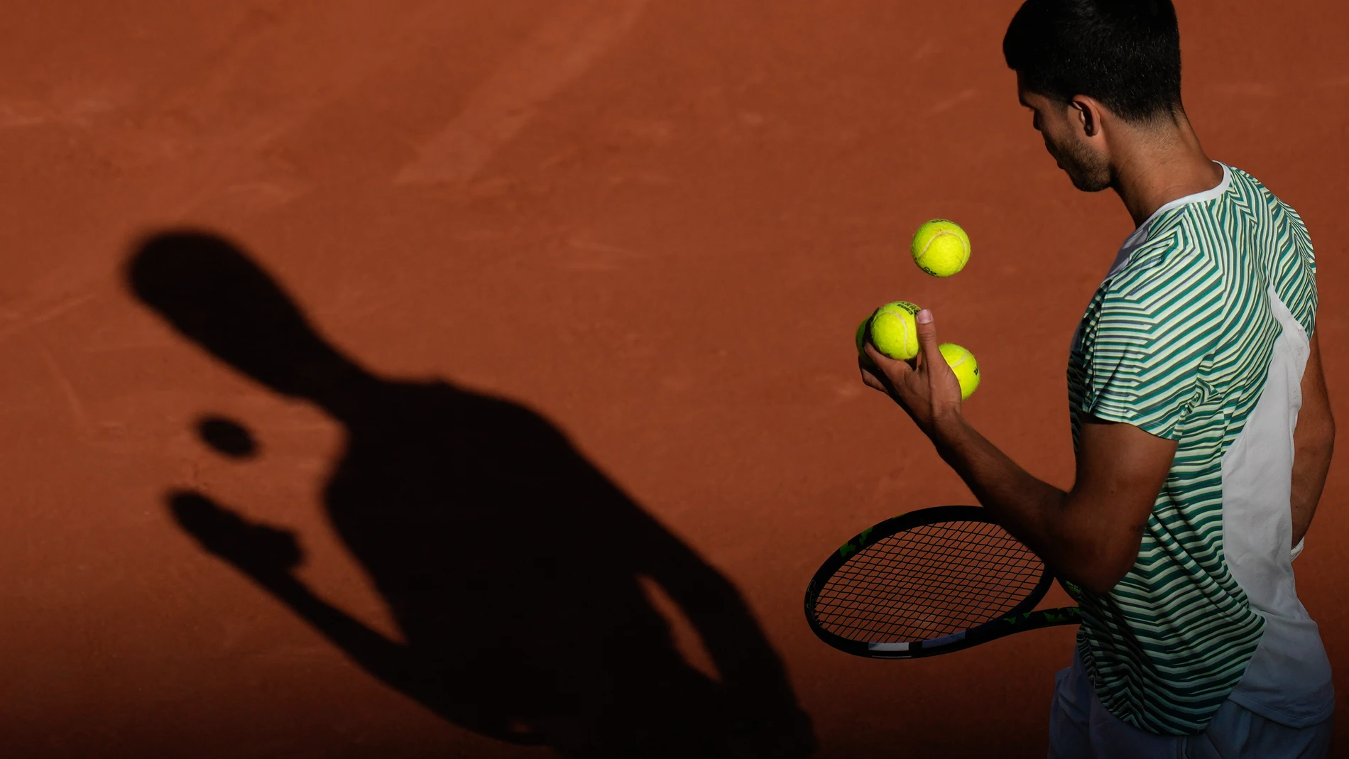 Spain's Carlos Alcaraz plays with 3 balls in his hand as he prepares to serve during his second round match of the French Open tennis tournament against Japan's Taro Daniel, at the Roland Garros stadium in Paris, Wednesday, May 31, 2023. (AP Photo/Thibault Camus)
