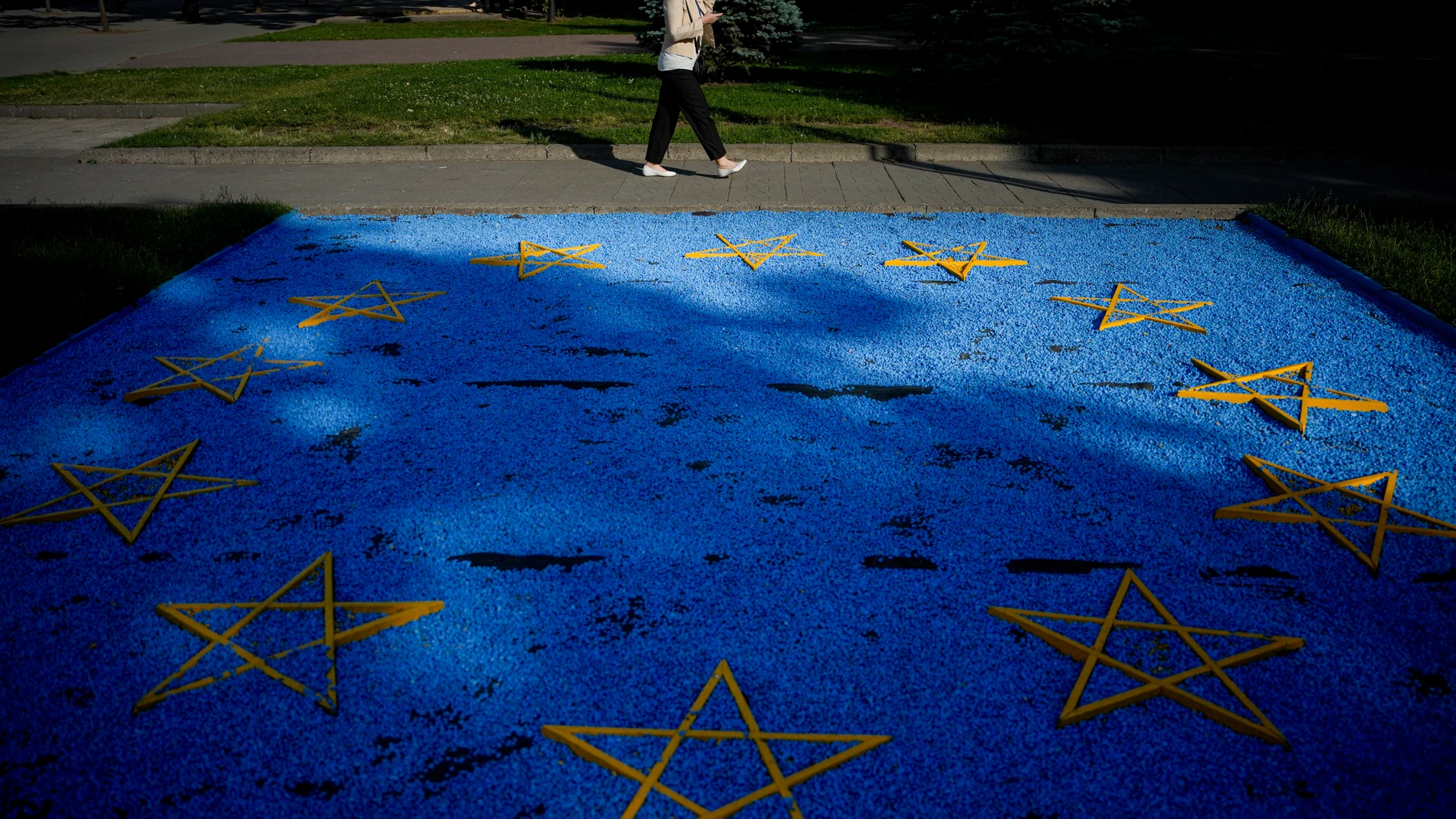 A woman walks by a EU flag installation in a park in Chisinau, Moldova, Wednesday, May 31, 2023. Final preparations for a major summit of European leaders are being made in Moldova, a sign of the Eastern European country’s ambitions to draw closer to the West. (AP Photo/Andreea Alexandru)
