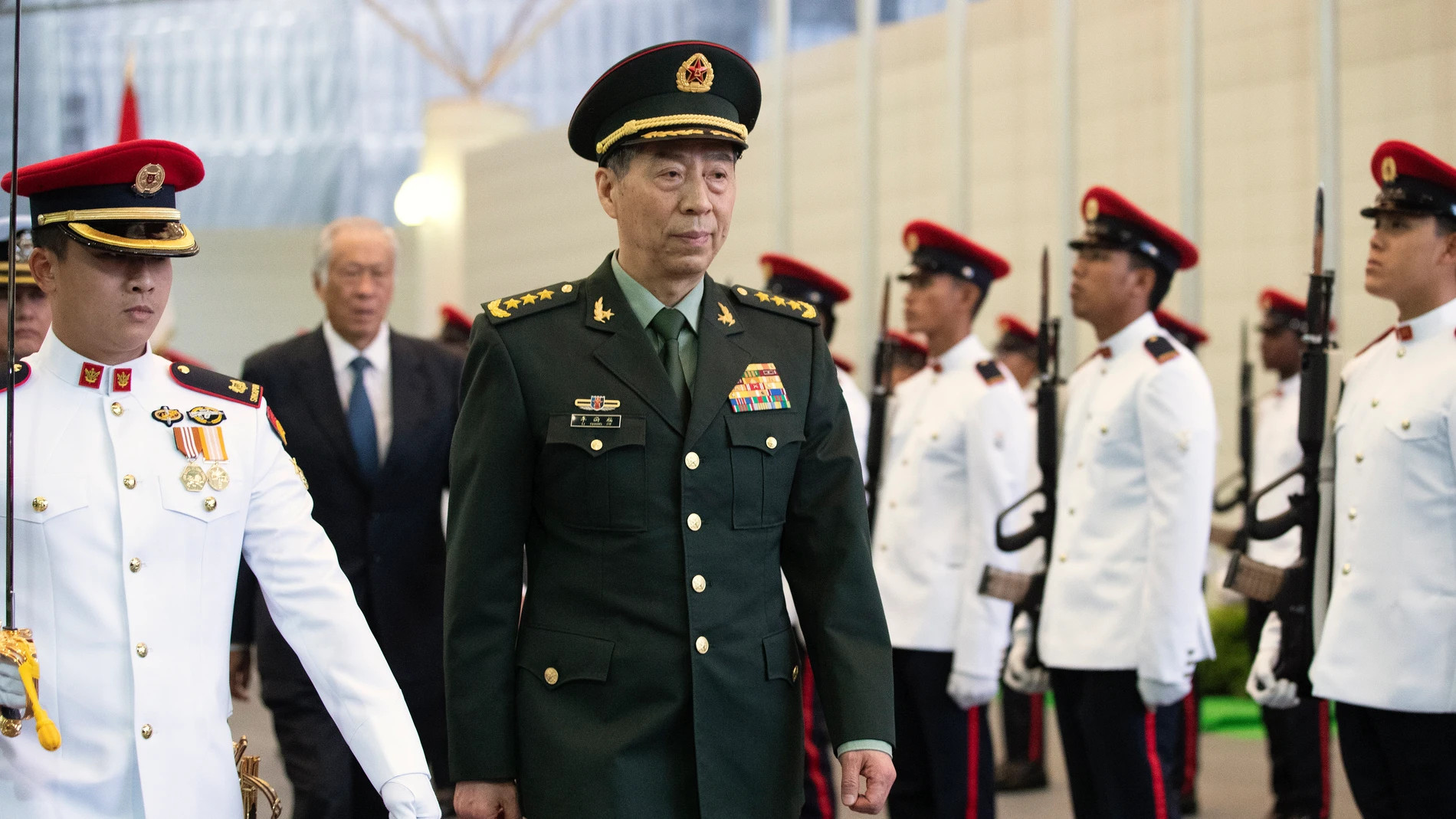 El ministro de Defensa de China, General Li Shangfu, seguido por su homólogo de Singapur, Ng Eng Hen, pasan revista a la guardia de honor