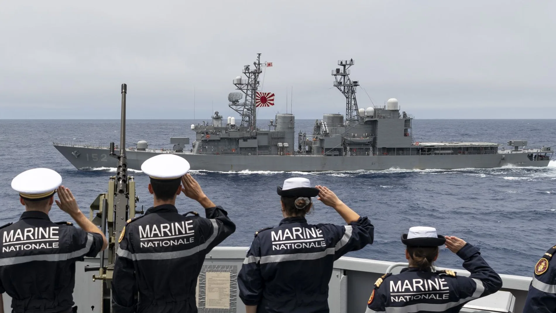 Marinos franceses del FS Lorraine saludan al paso del JS Yamagiri, buque de guerra japonés con la bandera del sol naciente
