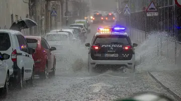 LA ALBERCA, (MURCIA), 31/05/2023.- Un coche de la policía local de Murcia circula por una calle inundada en la pedanía murciana de La Alberca tras la tormenta de lluvia y granizo que ha caido en la tarde de este miércoles. 9 rescates, 15 achiques y 23 obstáculos retirados de la vía son el balance provisional de las emergencias atendidas por las lluvias en la comunidad murciana esta tarde, cuando la Agencia Estatal de Meteorología ha elevado de amarillo a naranja el aviso por lluvias de hasta 35 litros por metro cuadrado y hora en la comarca de la vega del Segura hasta la medianoche.