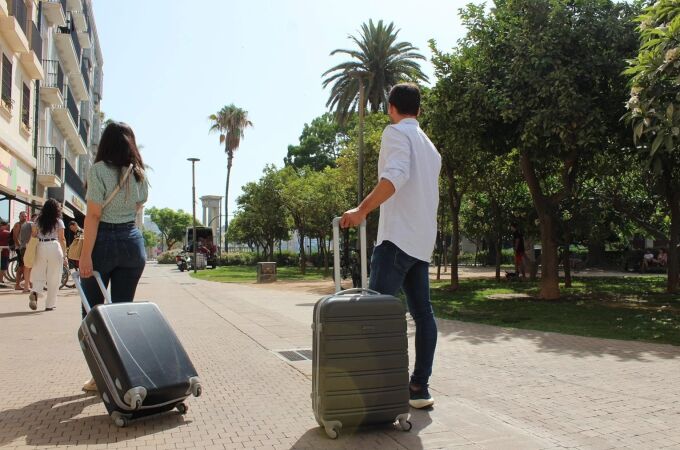 Dos turistas con sus maletas por el centro de Málaga, la ciudad que concentra la mayor oferta de pisos turísticos de Andalucía