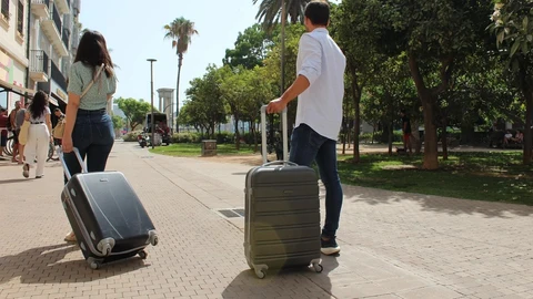 Dos turistas con sus maletas
