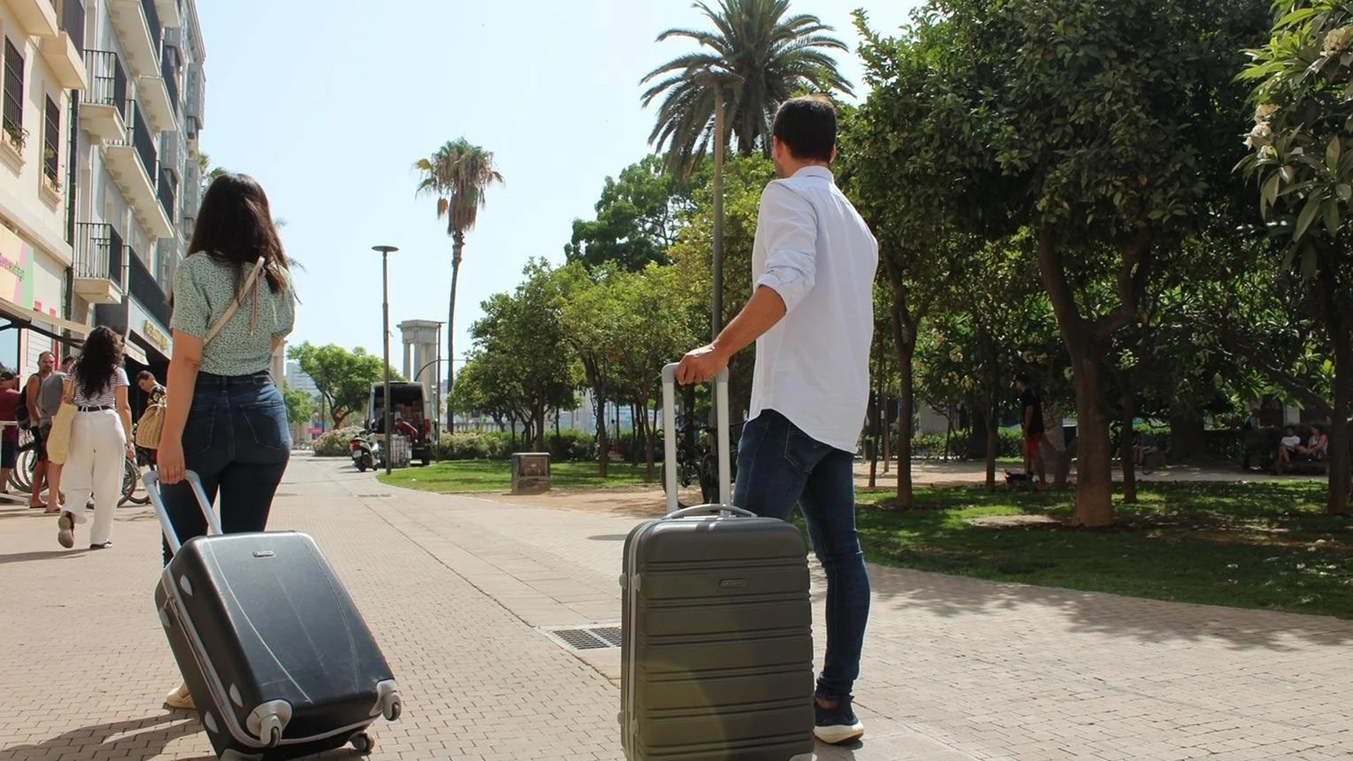 Dos turistas con sus maletas por el centro de Málaga, la ciudad que concentra la mayor oferta de pisos turísticos de Andalucía
