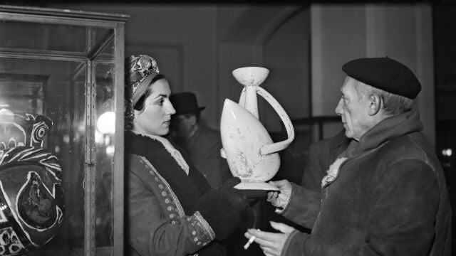 Spanish painter Pablo Picasso shows a pottery to his partner Francoise Gilot during his exhibition at the "Maison de la pensée", on November 24, 1948, in Paris. 