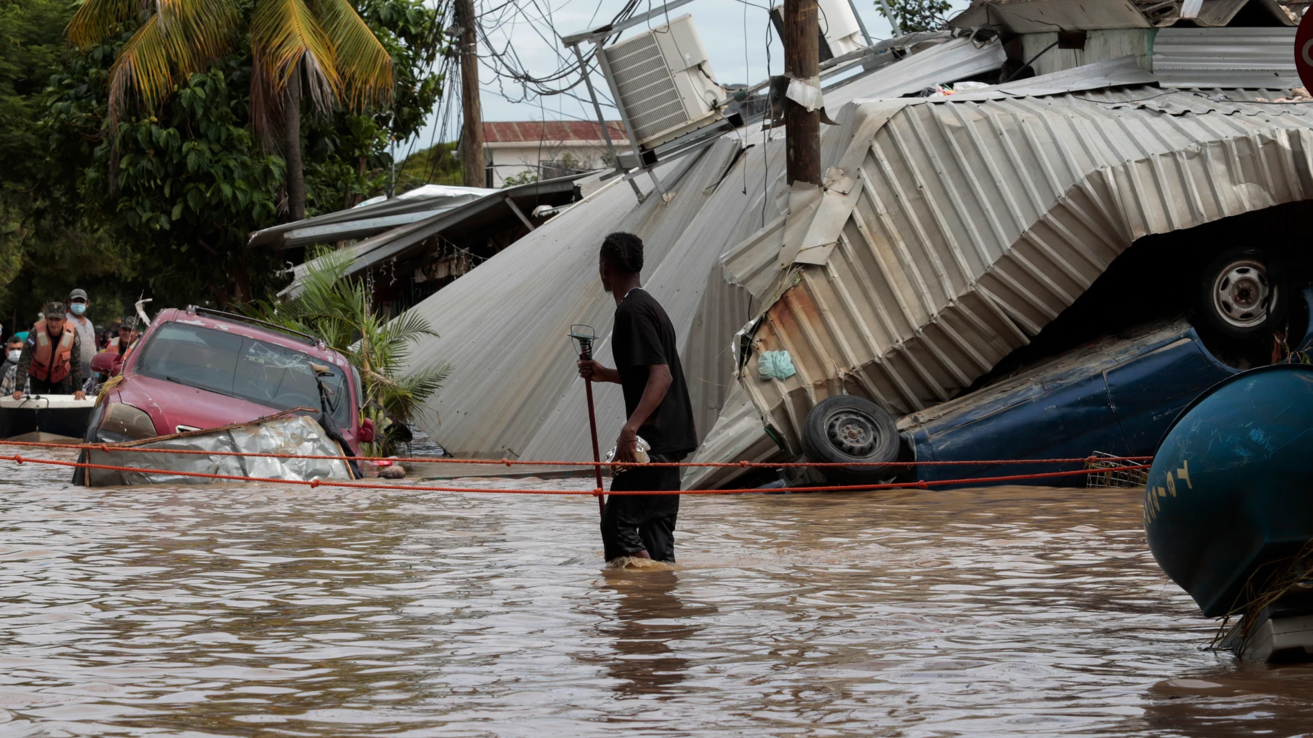 FILE - In this Nov. 6, 2020, file photo, a resident walking through a flooded street looks back at storm damage caused by Hurricane Eta in Planeta, Honduras. Environmental campaigners called Wednesday for fossil fuel producers to contribute to a new fund intended to help poor countries cope with climate disasters. (AP Photo/Delmer Martinez, File)